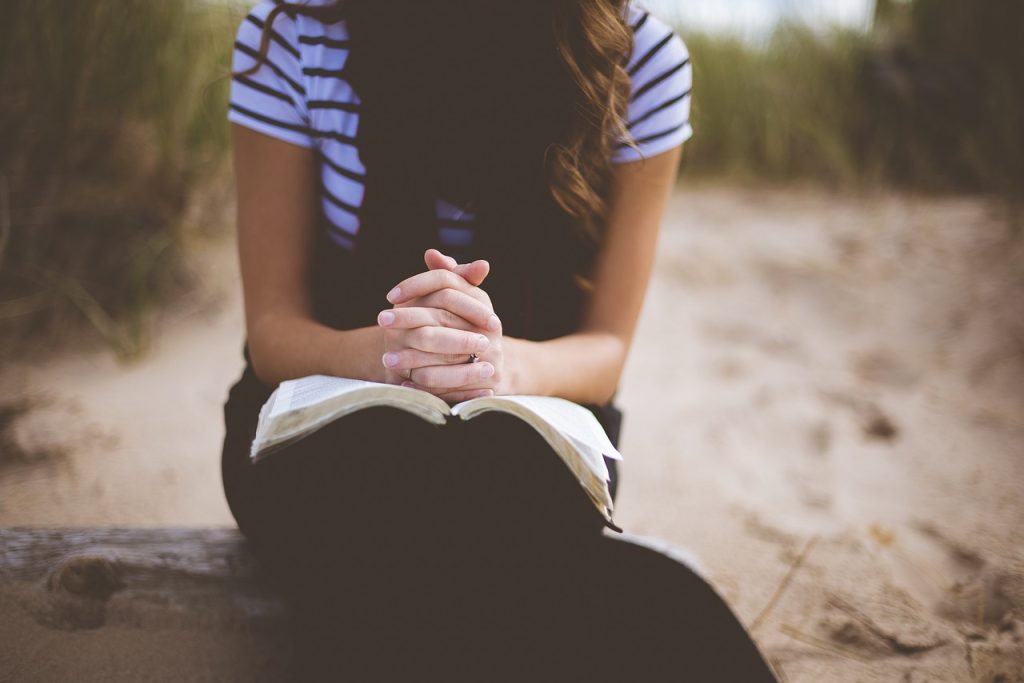 Woman sitting in nature with a Bible.
