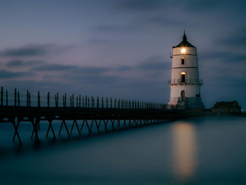 Lighthouse on the coastline during dusk, symbolizing hope, guidance, and building spiritual endurance.