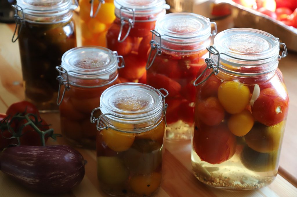 Jars of preserved vegetables showing food preservation as a way of fruga; homemaking.
