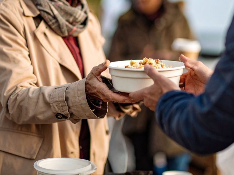 Volunteering at food bank during an outdoor winter gathering, reflecting acts of kindness and connection.